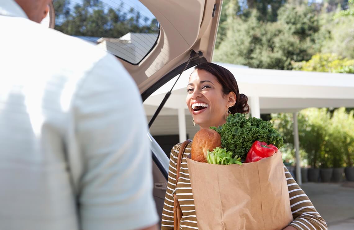 Woman holding paper bag with groceries