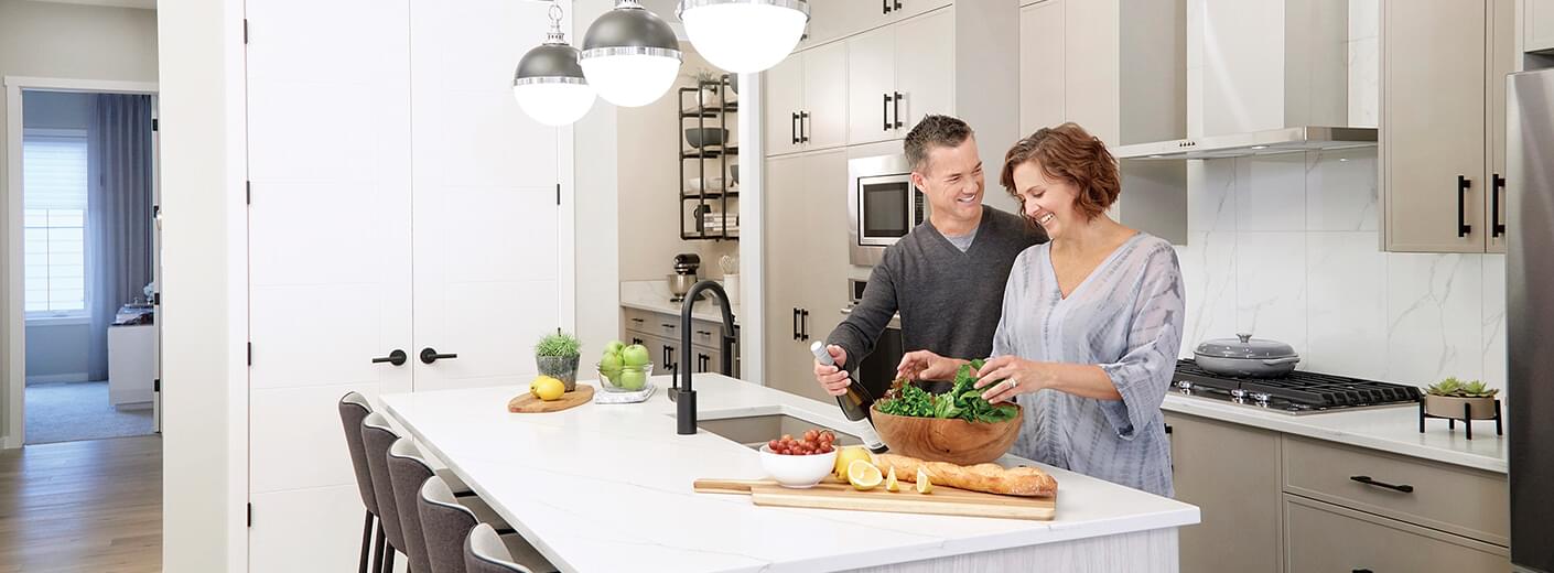 Couple preparing meal in a beautiful white kitchen