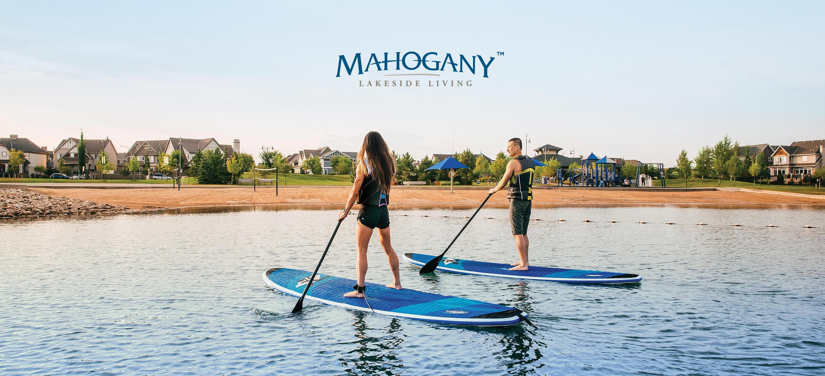 A couple stand-up paddleboarding on Mahogany Lake