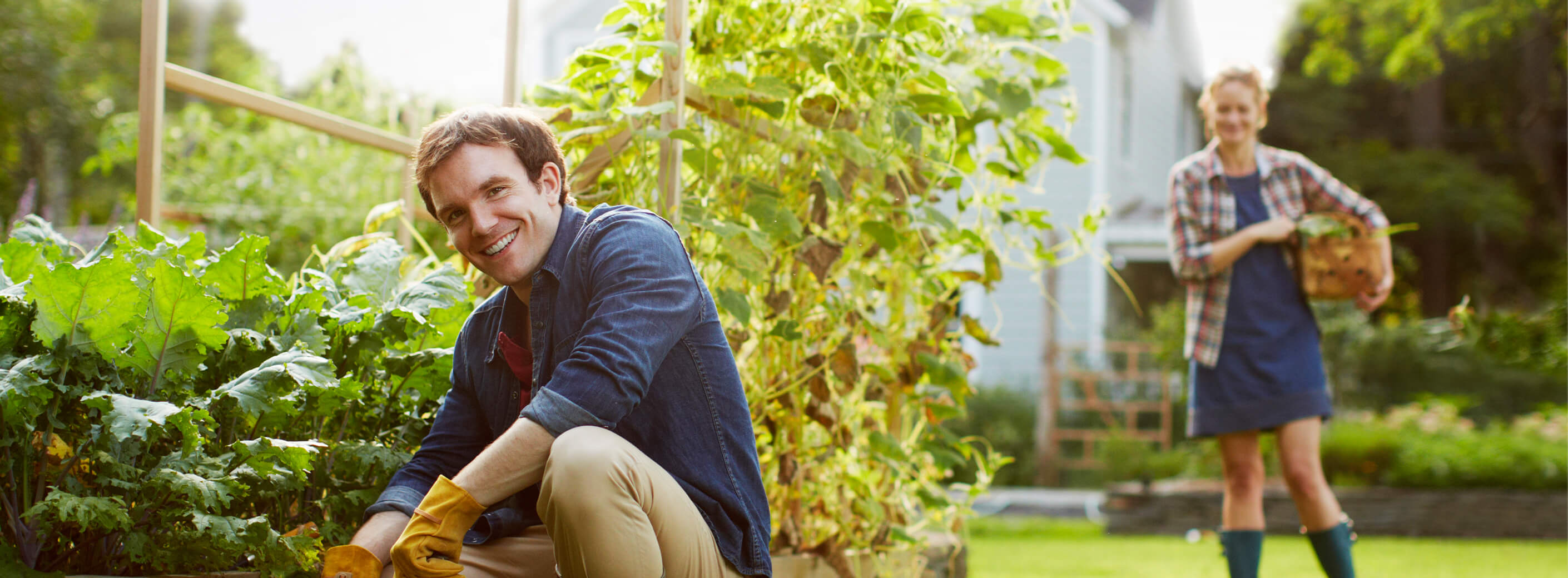 Man tending to garden with woman in background