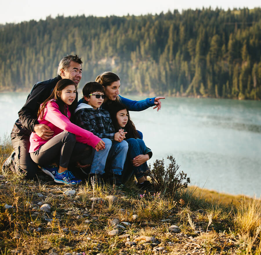 Family sitting along hill with wetland in background