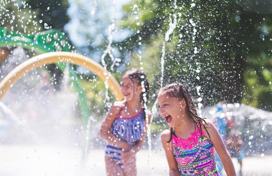 2 girls laughing at a splash park