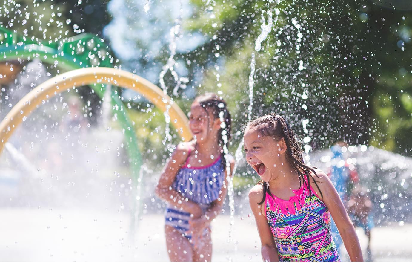 2 girls laughing at a splash park